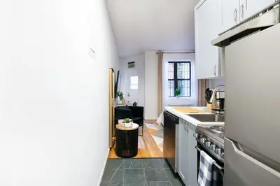 a kitchen with white cabinets and a sink at 74-1C New Studio With private outdoors - GYM in New York