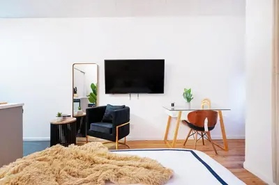 a living room with a tv and a table and chairs at 74-1C New Studio With private outdoors - GYM in New York