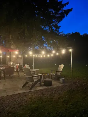 a patio with a table and chairs and lights at French Woods Farmhouse Bed & Breakfast in Hancock