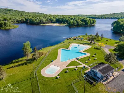 an aerial view of a lake with a swimming pool at The Oasis at Arrowhead in Arrowhead Lake