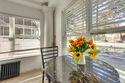 a dining room table with a vase of flowers on it at Chic Newark Vacation Rental 3 Mi to Airport! in Newark