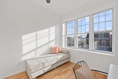 a white living room with a couch and windows at Jersey City Monthly Boutique 20 Min to NYC in Jersey City