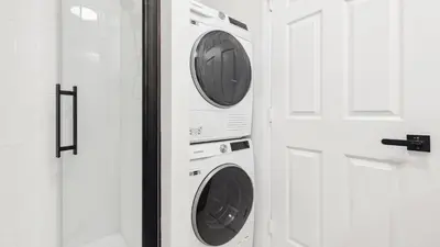 two washing machines in a bathroom next to a door at Jersey City Monthly Boutique 20 Min to NYC in Jersey City