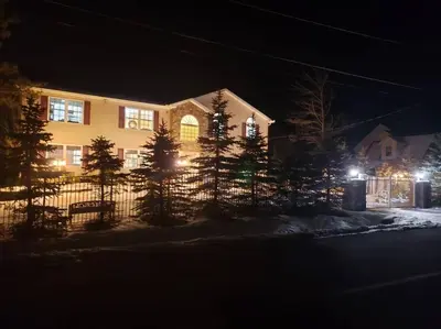a house with a fence in the snow at night at Stunning Lakefront Home - Swim, Fish, Kayak, HotTub in Long Pond