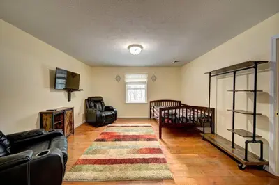 a living room with a couch and a crib at Stunning Lakefront Home - Swim, Fish, Kayak, HotTub in Long Pond