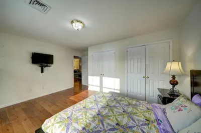 a bedroom with a bed and a flat screen tv at Stunning Lakefront Home - Swim, Fish, Kayak, HotTub in Long Pond