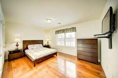 a bedroom with a bed and a large window at Stunning Lakefront Home - Swim, Fish, Kayak, HotTub in Long Pond