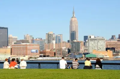 a group of people sitting on the grass overlooking a city at Spacious Oasis - Hoboken California King Bed! in Hoboken