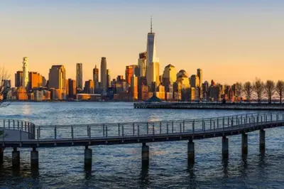 a bridge over the water in front of a city at Cozy apartment in beautiful midtown Hoboken in Hoboken