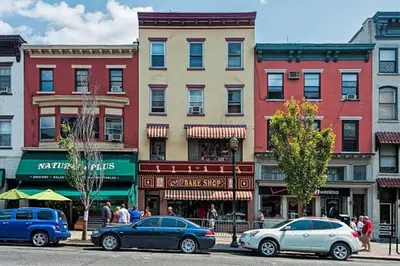 a city street with cars parked in front of buildings at Cozy apartment in beautiful midtown Hoboken in Hoboken