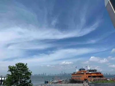 an orange cruise ship is docked at a pier at Studio by New York Harbor in Saint George