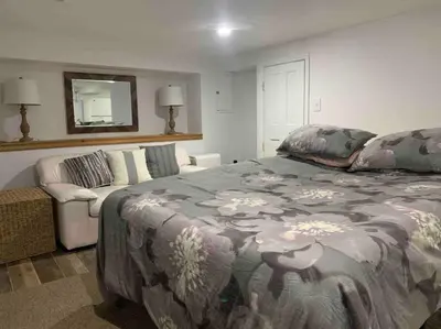 a bedroom with a large bed and a couch at Studio by New York Harbor in Saint George