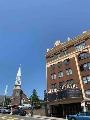 a building on a city street with a clock tower at Studio by New York Harbor in Saint George