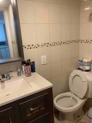 a bathroom with a toilet and a sink at Studio by New York Harbor in Saint George