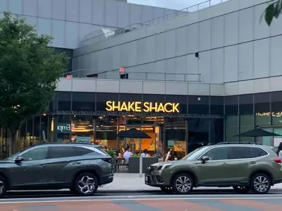 two cars parked in front of a shake shack building at Studio by New York Harbor in Saint George