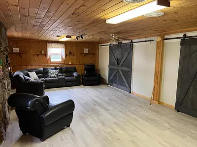 a living room with a leather couch and a barn door at Wellsboro Rail Trail 1 in Wellsboro