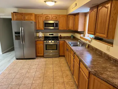a kitchen with wooden cabinets and stainless steel appliances at Wellsboro Rail Trail 1 in Wellsboro