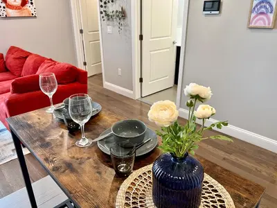 a wooden table with a vase of flowers and wine glasses at 304Stunning and comfy 1BDR APT in Center city in Philadelphia