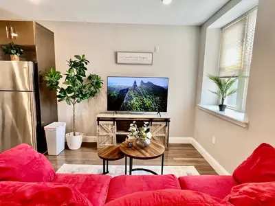 a living room with a red couch and a tv at 304Stunning and comfy 1BDR APT in Center city in Philadelphia