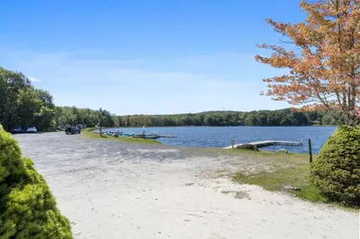 a sandy beach next to a body of water at Rustic Luxury in the Pocono Mountains - Stag Lodge in Pocono Lake