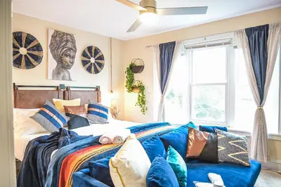 a bedroom with a bed and a blue couch at Chic 4BR Dwelling with Backyard in Philadelphia in Philadelphia