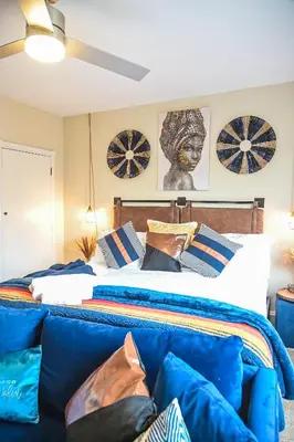 a bedroom with a bed and a blue couch at Chic 4BR Dwelling with Backyard in Philadelphia in Philadelphia