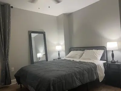 a bedroom with a bed with a mirror and lamps at Little France Phillipsburg in Phillipsburg