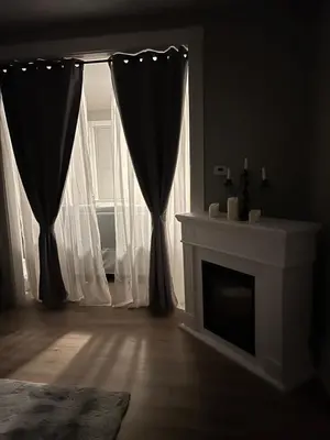 a living room with a window with curtains and a fireplace at Little France Phillipsburg in Phillipsburg