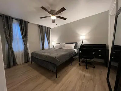 a bedroom with a bed with a ceiling fan and a desk at Little France Phillipsburg in Phillipsburg