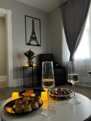a table with two glasses of wine and a plate of food at Little France Phillipsburg in Phillipsburg