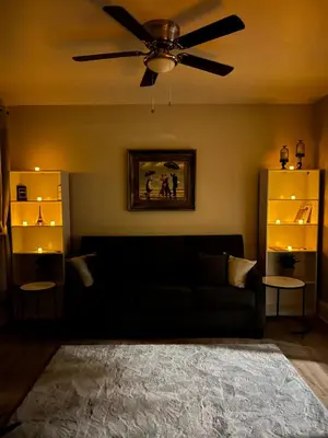 a living room with a black couch and a ceiling fan at Little France Phillipsburg in Phillipsburg