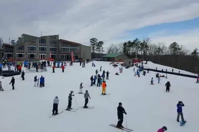 a group of people skiing on a snow covered slope at Magical Waterfront with 4-Season fun in Ski Resort in Lackawaxen
