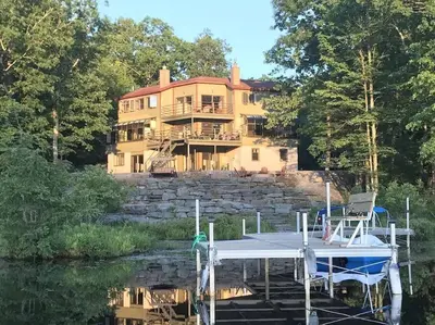 a house on the side of a lake with a dock at Magical Waterfront with 4-Season fun in Ski Resort in Lackawaxen