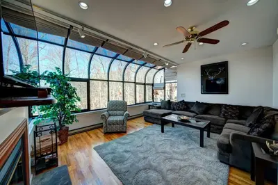 a living room with a couch and a ceiling fan at Magical Waterfront with 4-Season fun in Ski Resort in Lackawaxen