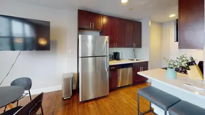 a kitchen with a stainless steel refrigerator and wooden cabinets at Avenue A909 Comfy 2Br, Pool, Gym, Parking in Philadelphia