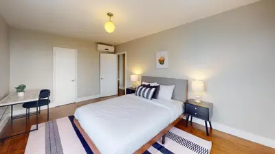 a bedroom with a bed and a desk with two lamps at Avenue A909 Comfy 2Br, Pool, Gym, Parking in Philadelphia