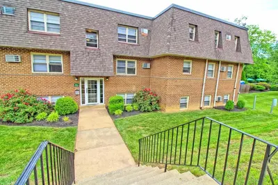 a brick house with a gate in the yard at Pine Brook 1322 I Pool Gym I Free Parking ! in Newark