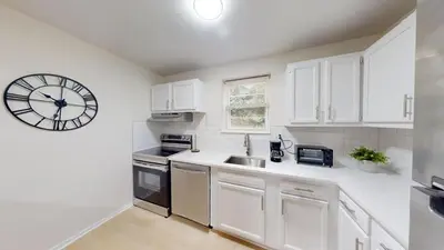 a white kitchen with a large clock on the wall at Pine Brook 804 I Pool Gym I Free Parking ! in Newark