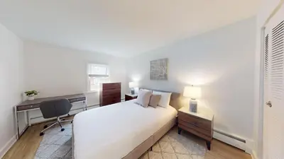 a bedroom with a bed and a desk and a chair at pb 824 Furnished 2br Pool Gym Parking pb in Newark