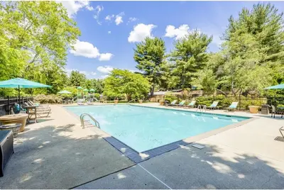 a swimming pool with chairs and umbrellas at pb 824 Furnished 2br Pool Gym Parking pb in Newark