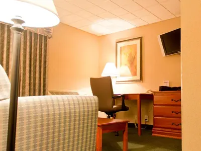 a hotel room with a desk and a chair at Quality Inn East Stroudsburg - Poconos in East Stroudsburg