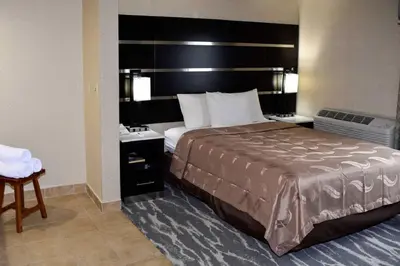 a hotel room with a large bed with a large headboard at Quality Inn East Stroudsburg - Poconos in East Stroudsburg
