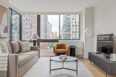 a living room with a couch and a table at UWS 2BR w Elevator Gym DM Playroom Rooftop NYC-868 in New York