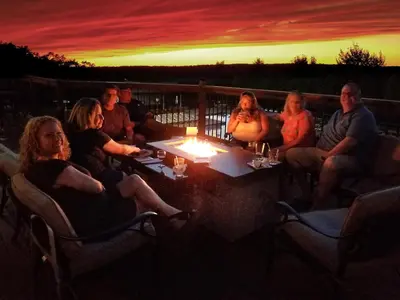 a group of people sitting around a table at sunset at Luxury getaway in woods, Jacuzzi, Hot Tub, Pool in Bushkill