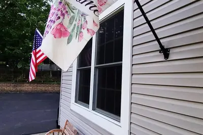 a flag on the side of a house with a window at Luxury getaway in woods, Jacuzzi, Hot Tub, Pool in Bushkill