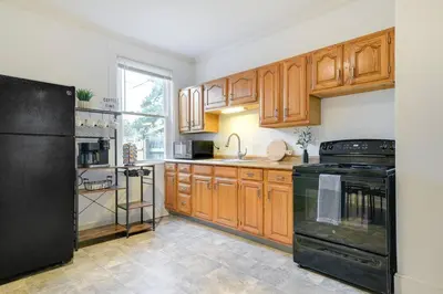 a kitchen with wooden cabinets and a black refrigerator at Cozy Retreat in Downtown Lancaster with Backyard Patio in Lancaster