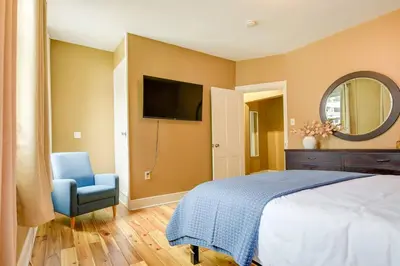 a bedroom with a bed and a chair and a mirror at Cozy Retreat in Downtown Lancaster with Backyard Patio in Lancaster