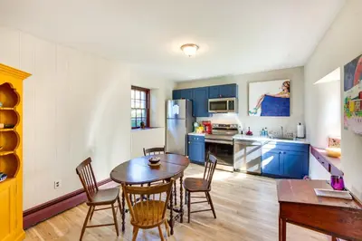 a kitchen with blue cabinets and a table and chairs at Jim Croces Farmhouse Apartment in Downingtown! in Downingtown