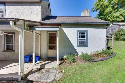 a small white house with a front porch at Jim Croces Farmhouse Apartment in Downingtown! in Downingtown