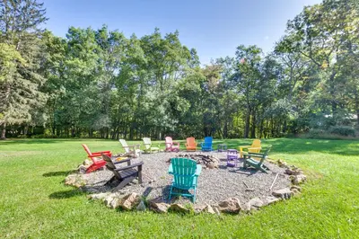 a group of colorful chairs sitting in a circle in the grass at Jim Croces Farmhouse Apartment in Downingtown! in Downingtown